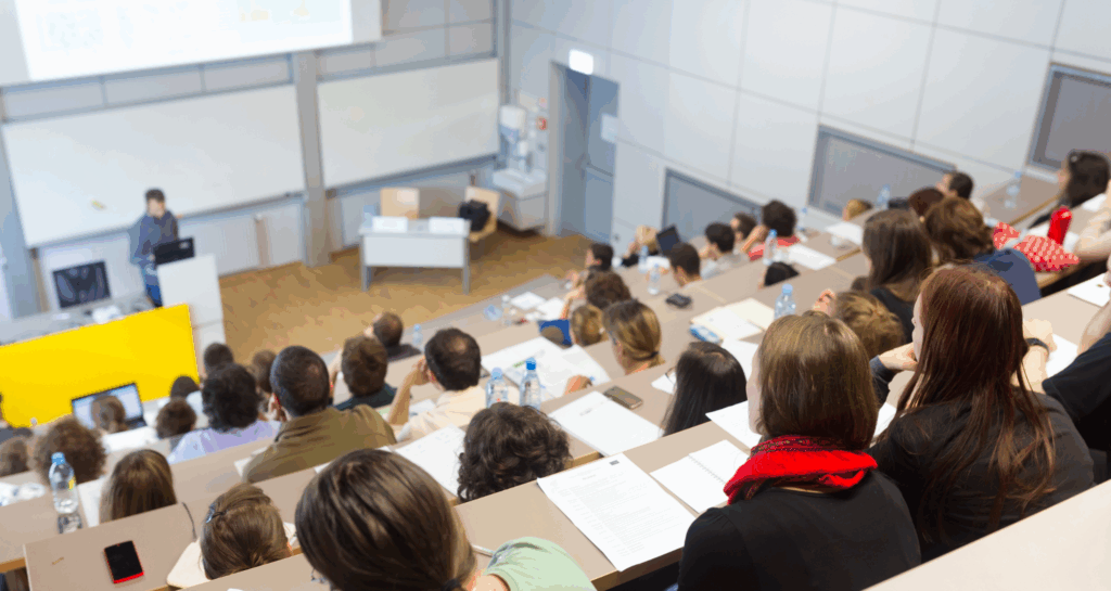Speaker giving presentation in a university lecture hall.