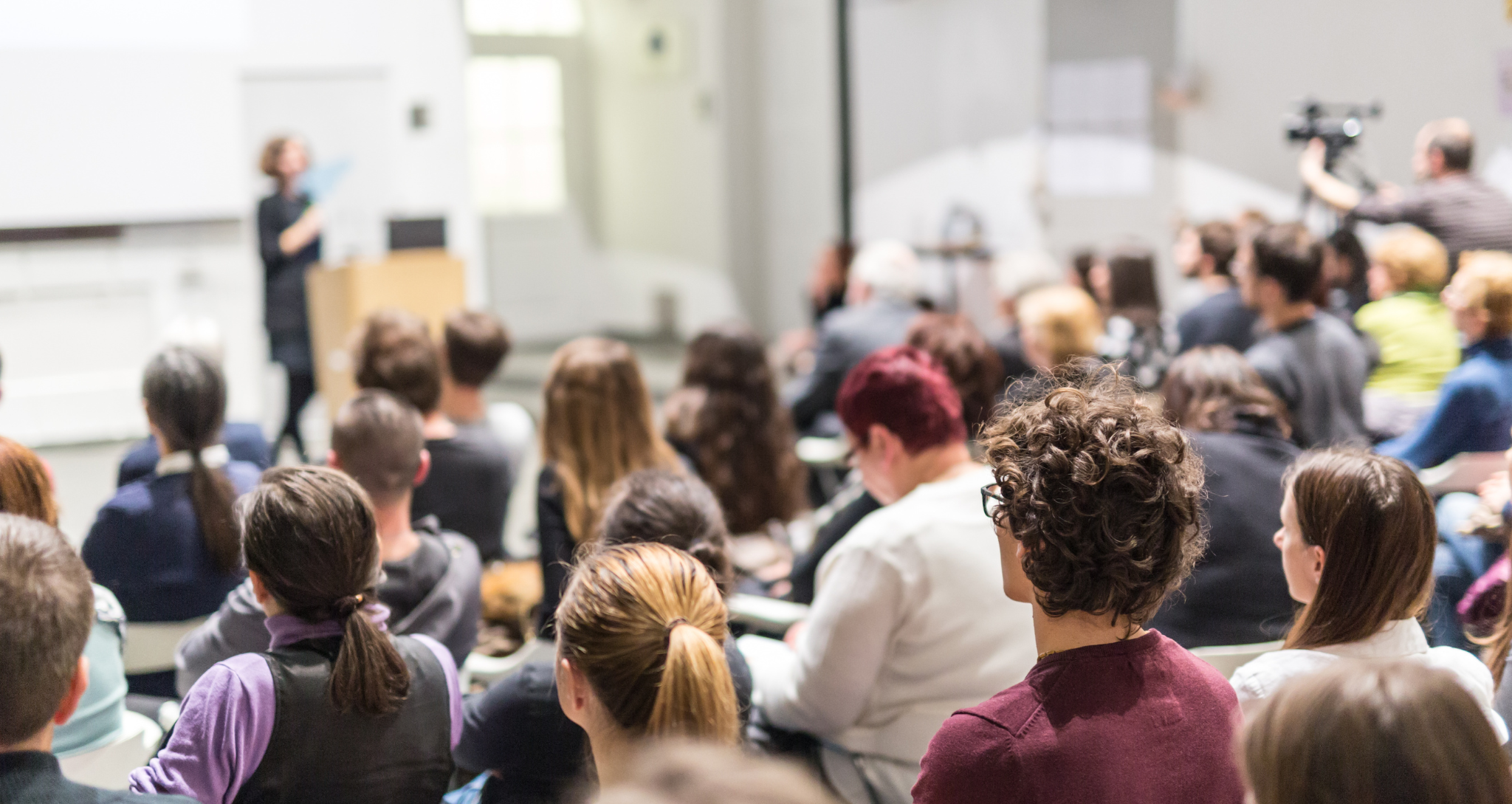Speaker giving presentation in a university lecture hall.